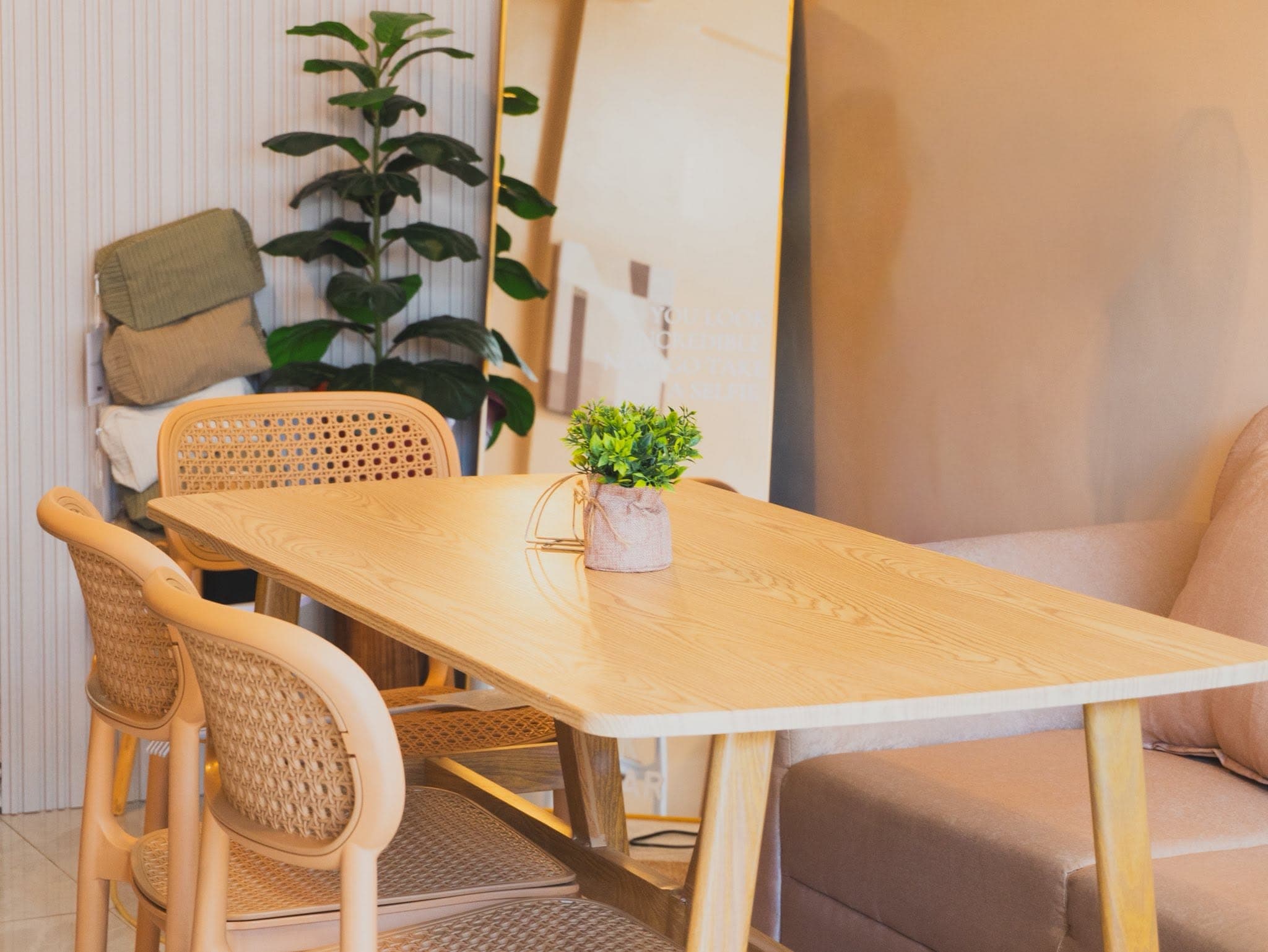 A cozy BLCK SUGAR table with woven chairs and plants